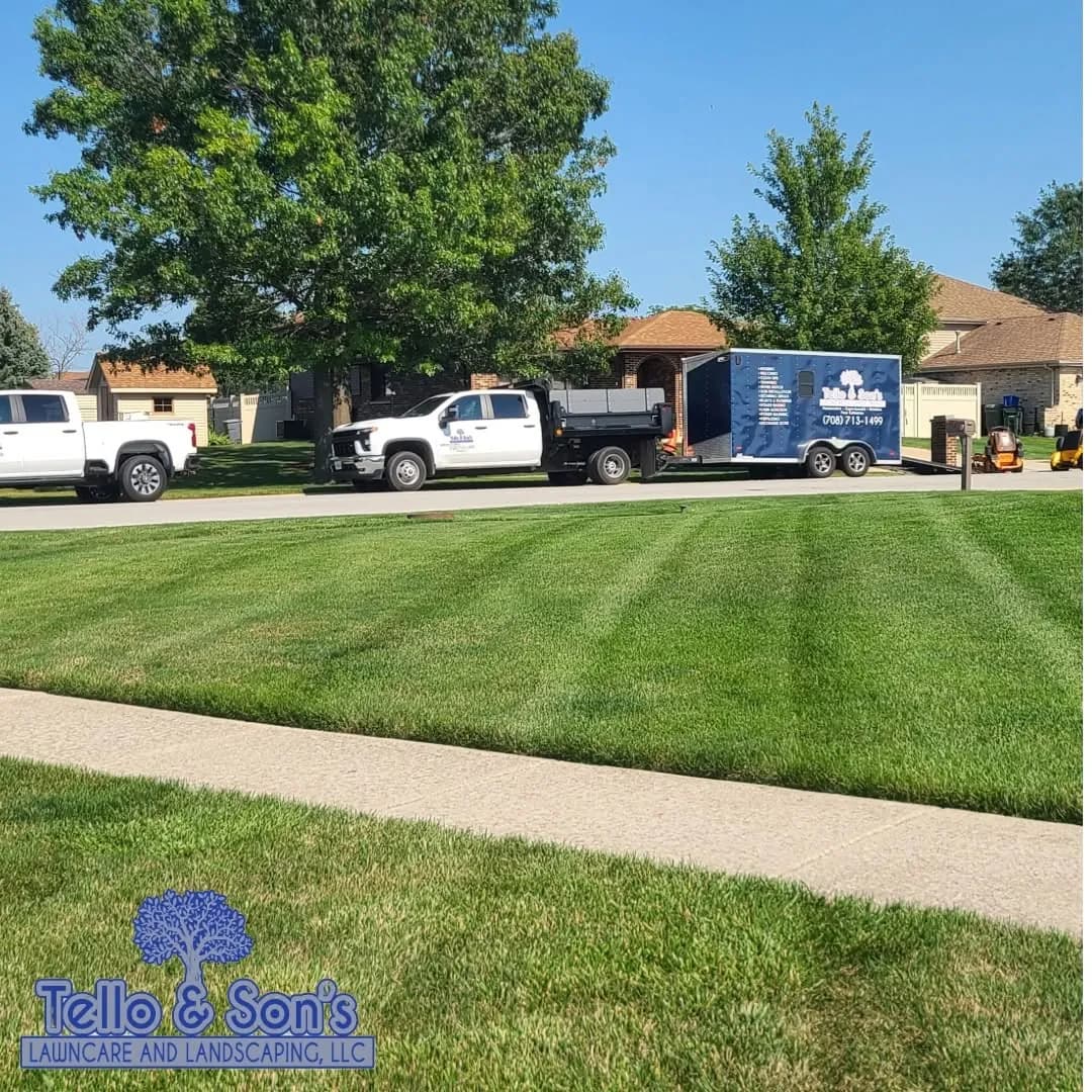 Branded Tello & Son's truck, enclosed trailer and mower on a freshly striped lawn