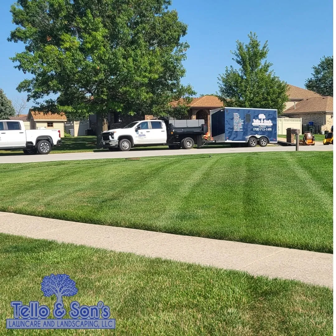 Branded Tello & Son's truck, enclosed trailer and mower on a freshly striped lawn