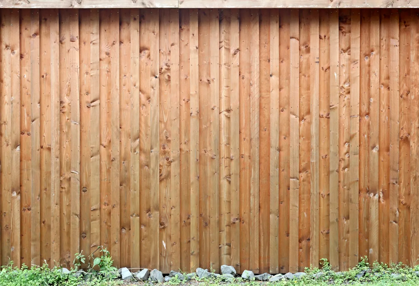 New wood privacy fence installation in a suburban backyard