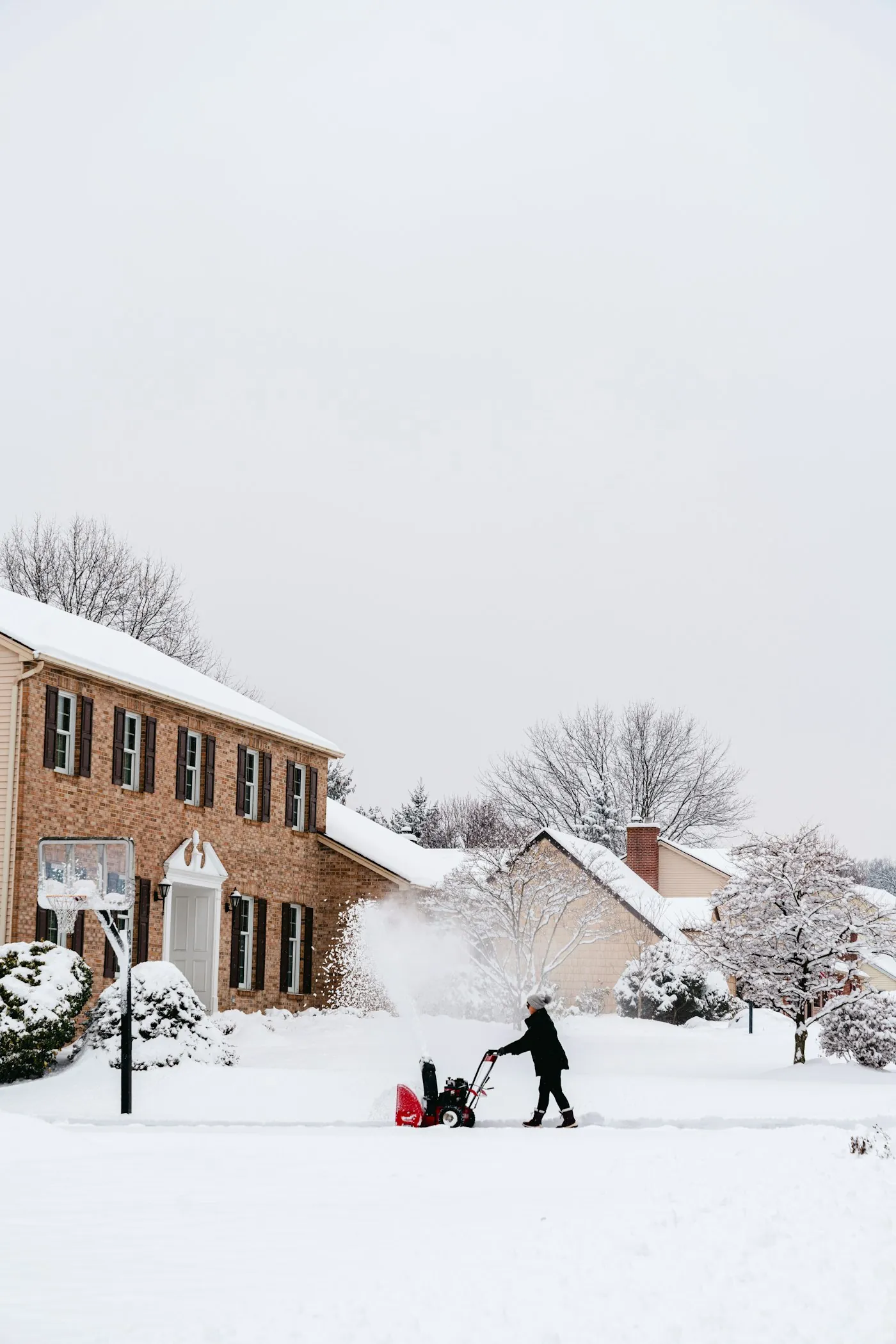 Residential driveway being cleared of snow on a winter morning